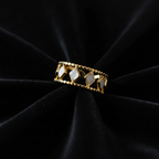 Gold diamond cutout lace crown ring on black velvet fabric