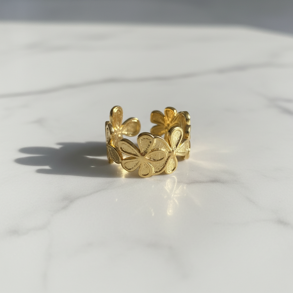 Gold flower bloom open cuff ring on white marble surface
