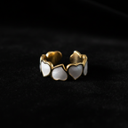 Gold white enamel heart band open cuff ring on black velvet with dramatic lighting