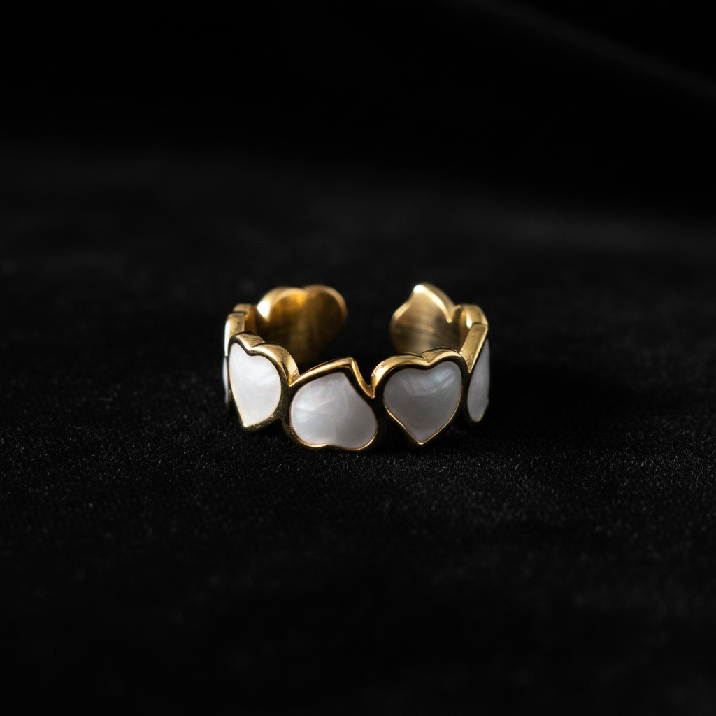 Gold white enamel heart band open cuff ring on black velvet with dramatic lighting