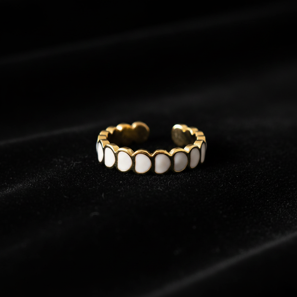 Gold white oval enamel wide band open cuff ring on black velvet with dramatic lighting