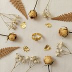 Gold coin ring flat lay with dried flowers