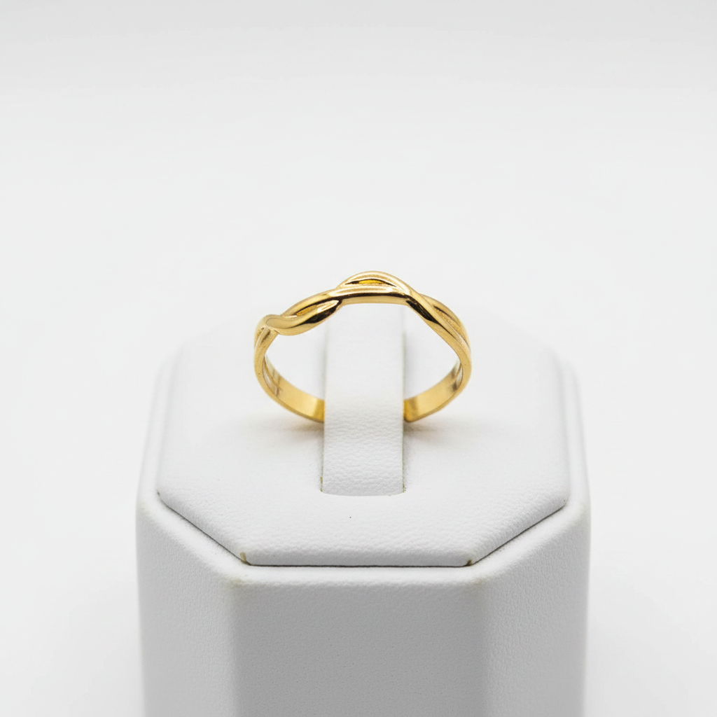 Gold twisted braided band open cuff ring on white jewelry stand, clean studio shot