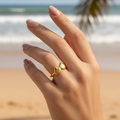 Gold triple seashell open band ring worn on woman's finger