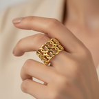 Gold Interlocking Wave Chain Wide Cuff Open Ring - worn on finger cream background lifestyle shot
