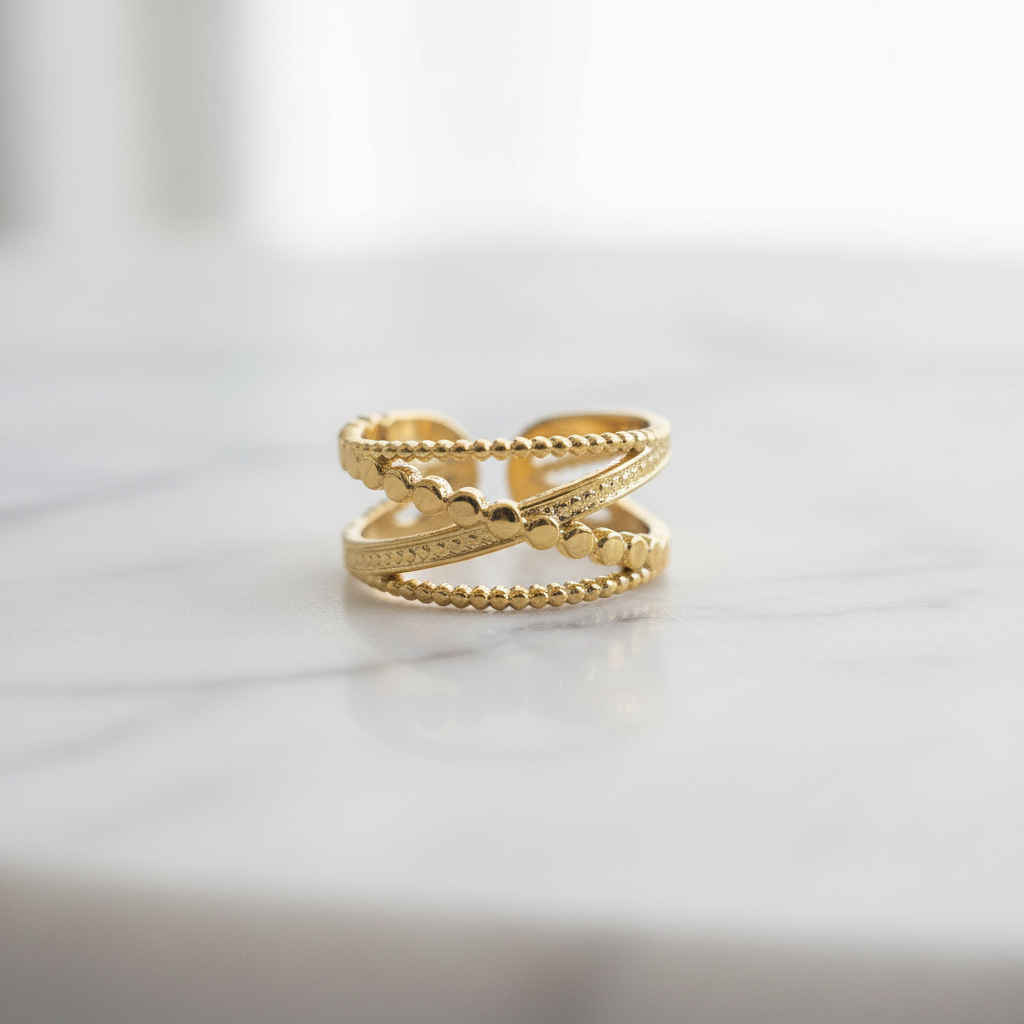 Gold double layer beaded heart open cuff ring on white marble surface