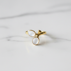 Gold double oval stone bypass open cuff ring on white marble surface
