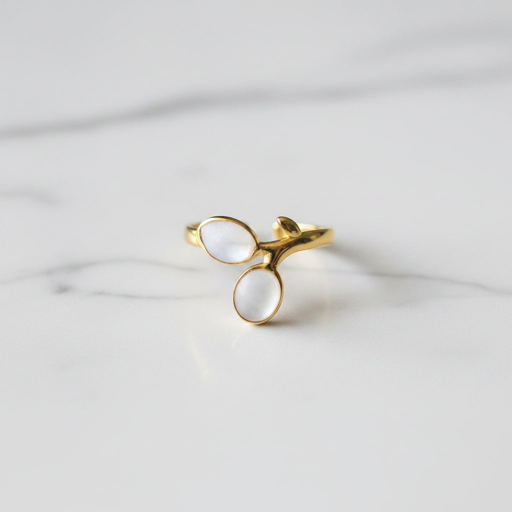 Gold double oval stone bypass open cuff ring on white marble surface