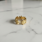 Gold daisy flower open cuff ring on white marble surface
