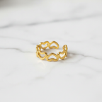 Gold open heart cutout band open cuff ring on white marble surface