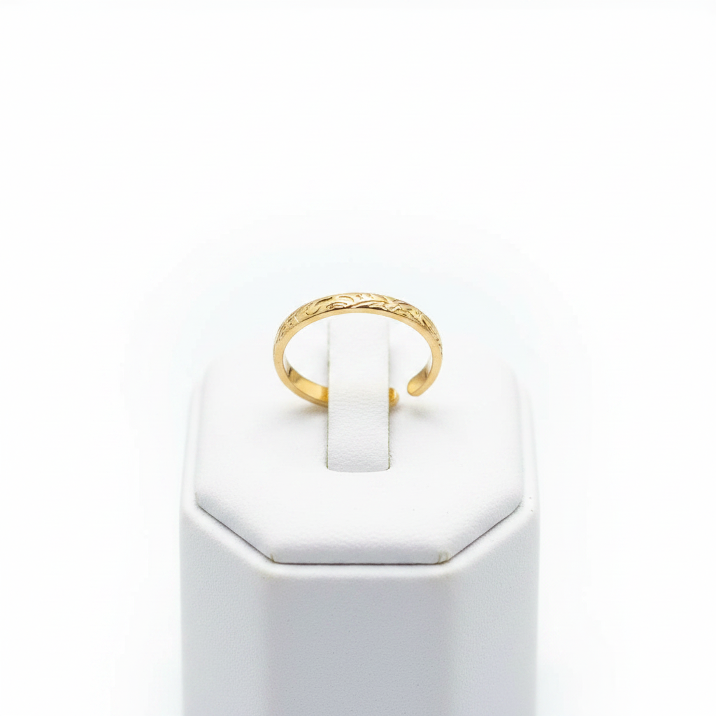 Gold engraved floral band open cuff ring on white jewelry stand, clean studio shot