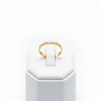 Gold engraved floral band open cuff ring on white jewelry stand, clean studio shot