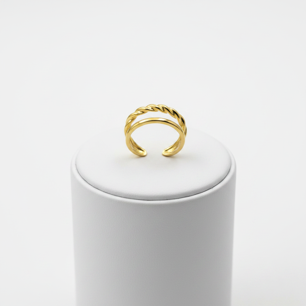 Gold double band twisted rope and plain open cuff ring on white jewelry stand, clean studio shot