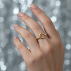 Gold moon and moonstone open band ring worn on woman's finger