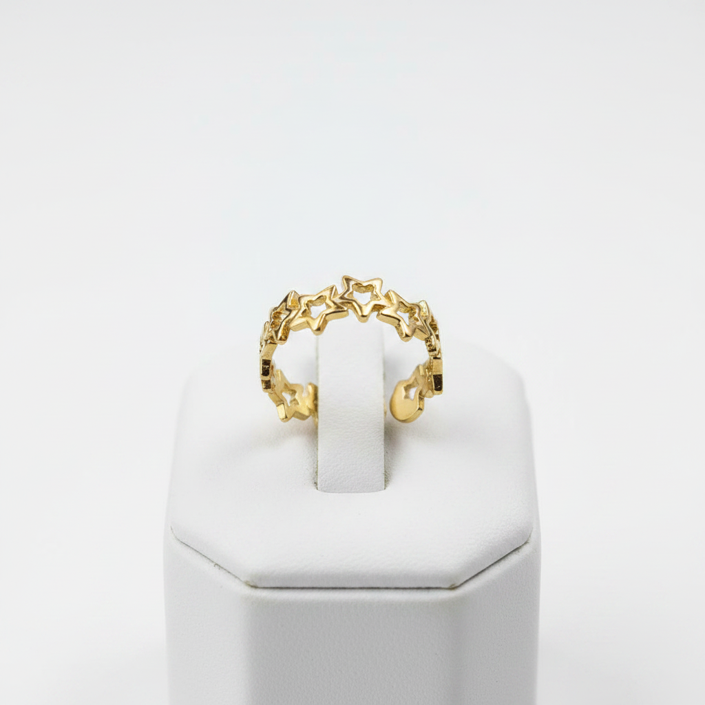 Gold linked star cutout band open cuff ring on white jewelry stand, clean studio shot