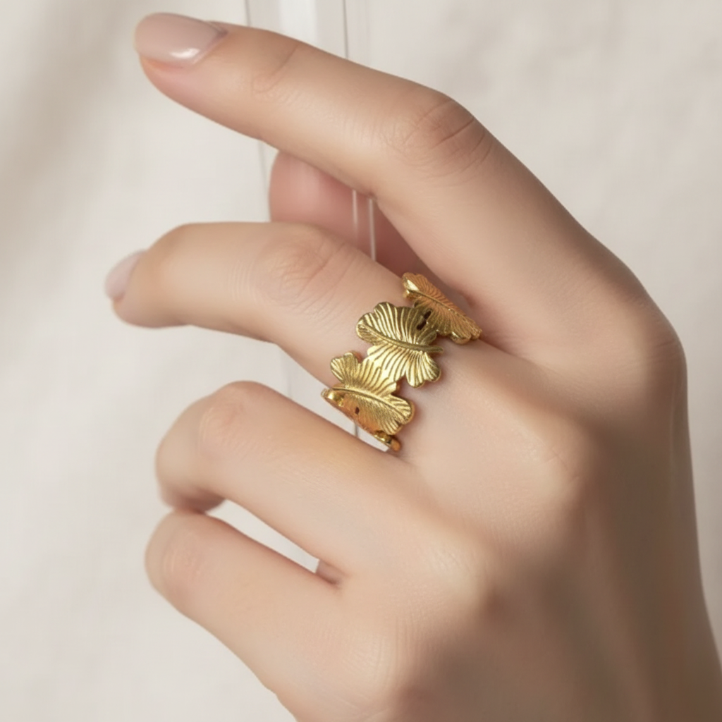 Gold Ginkgo & Tropical Leaf Wrap Adjustable Open Ring - worn on finger cream background lifestyle shot