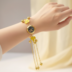 Yellow flower bracelet watch on wrist against cream background